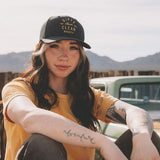 Lexi wearing the Juno curved brim hat with the slogan Dirty Hands Clean Money